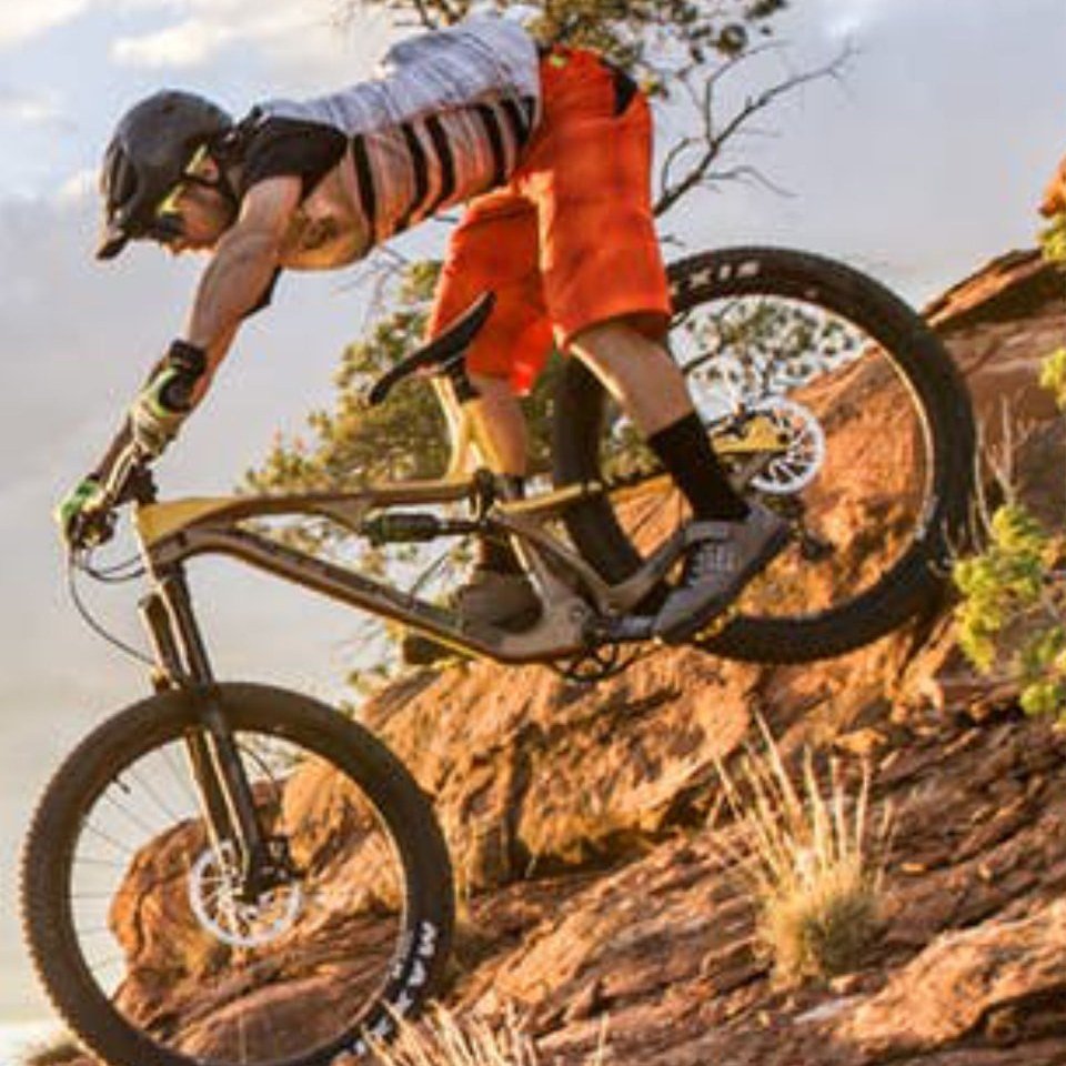 Ciclista descendo trilha de downhill em terreno rochoso